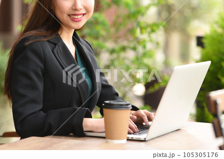 屋外でPCを操作する若いアジア人の女性 105305176