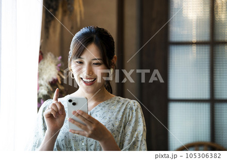カフェでスマホを操作する女性 105306382