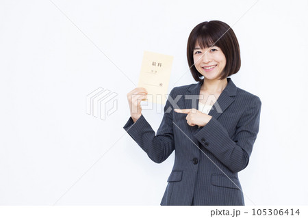 白い背景の前で給料袋を持つスーツ姿の働く女性 白い背景の前で給料袋を持つスーツ姿の働く女性 105306414