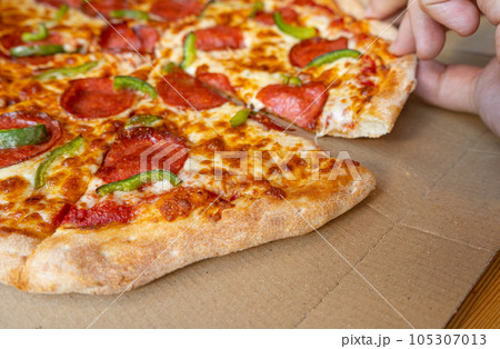 Pepperoni Pizza in Cardboard Delivery Box Closeup, Salami Pizza with Green Paprika, Chili Pepper 105307013