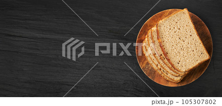 Brown Bread Slices on Black Plate Background 105307802