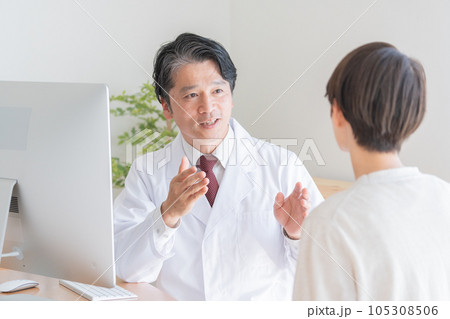 女性患者を診察する医者 105308506