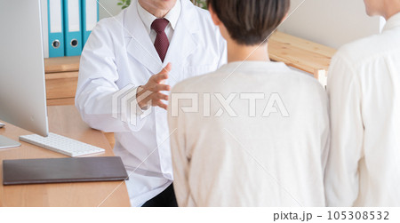 医者と診察を受ける夫婦 105308532