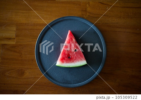 黒い皿に置いた一切れのスイカ 105309522