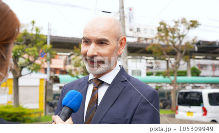 街頭インタビューを受ける外国人男性 105309949