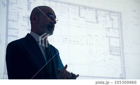 プロジェクターを使って作戦を説明する男性のシルエット 105309960