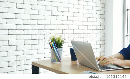 Asian Female freelance using laptop at home office desk. Woman reading financial graph chart Planning analyzing marketing data. Asian female people working office firm with business stuff, coffee cup 105312145