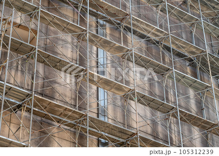 老朽化で汚れたビルの外壁と仮設足場 105312239