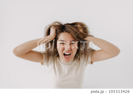 Angry face of woman in white t-shirt isolated on white. 105313426