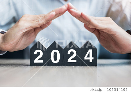 Businessman hands over 2024 Happy New Year with house model on table office. Property insurance and real estate concepts 105314193