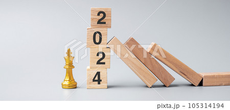 wooden Dominoes falling against 2024 stop blocks with golden Chess King figure. Business, Risk Management, Solution, economic, Insurance and New Year concept wooden Dominoes falling against 2024 stop blocks with golden Chess King figure. Business, Risk Management, Solution, economic, Insurance and New Year concept 105314194