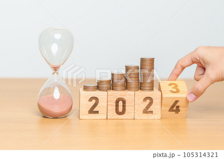 Happy New Year with sandglass and flipping 2023 change to 2024 block. Resolution, Goals, Plan, Action, Money Saving, Retirement fund, Pension, Investment and Financial concept 105314321