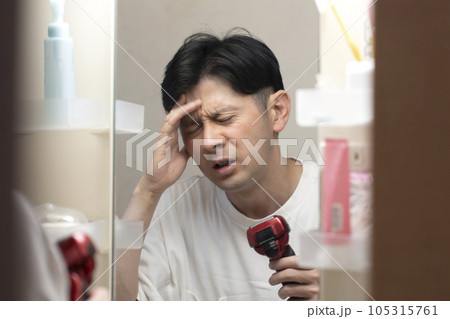 睡眠不足が辛い男性　頭痛　二日酔い　 105315761