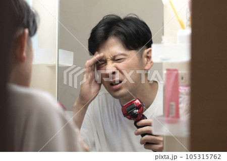 睡眠不足が辛い男性　頭痛　二日酔い　 105315762