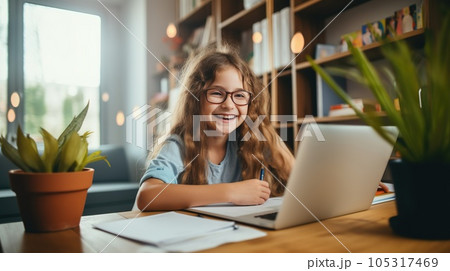 Happy child and adult are sitting at desk. Girl doing homework or online education 105317469
