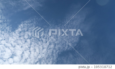 Heavenly white clouds on the blue sky with the sun appeared perfect for multimedia texture or background and content creation Heavenly white clouds on the blue sky with the sun appeared perfect for multimedia texture or background and content creation 105318712