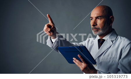 タブレットを持って指を差す白衣を着た外国人男性 105319773