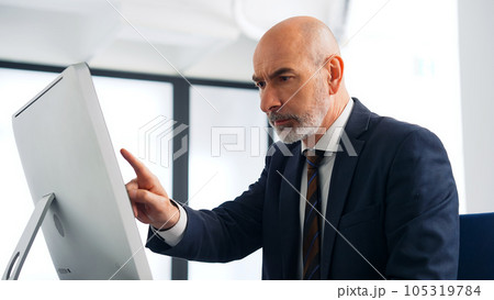 オフィスでパソコンを使って作業するビジネスマン オフィスでパソコンを使って作業するビジネスマン 105319784