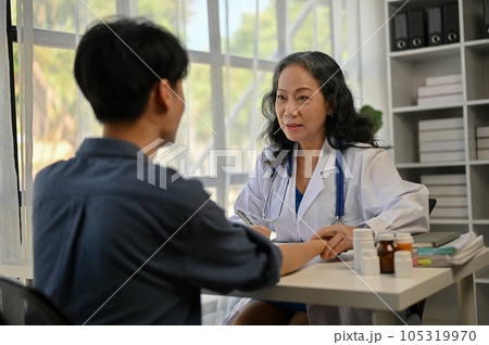 A professional Asian doctor is giving a consultation on a treatment plan to a male patient A professional Asian doctor is giving a consultation on a treatment plan to a male patient 105319970