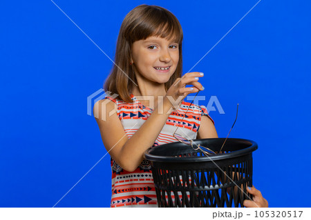 Preteen child kid girl taking off throwing out glasses into bin after vision laser treatment therapy Preteen child kid girl taking off throwing out glasses into bin after vision laser treatment therapy 105320517