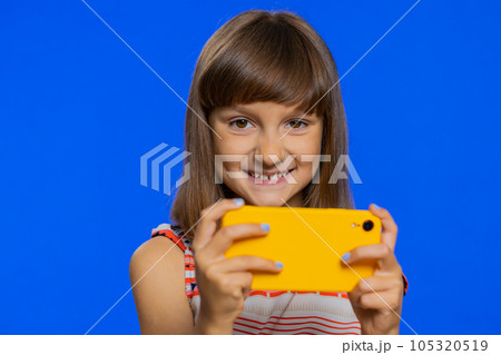 Preteen child kid girl enthusiastically playing racing or shooter video games on smartphone app Preteen child kid girl enthusiastically playing racing or shooter video games on smartphone app 105320519