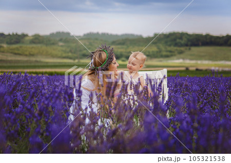 It is a picture of a small girl with her mother wearing a lavender wreath 105321538