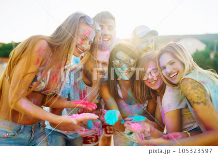 A group of friends have fun, dance at the holi festival. Celebrating traditional indian spring holiday. Friendship. 105323597