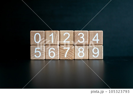 Several wooden blocks arranged from 0-9 horizontally against a black background. 105323793