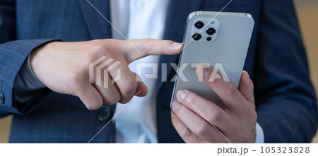 スマホを操作する若い男性の手元 パーツ バナーサイズ スマホを操作する若い男性の手元 パーツ バナーサイズ 105323828