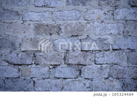 A gray wall of large blocks. Grey cinder block. The wall of an industrial building. A gray wall of large blocks. Grey cinder block. The wall of an industrial building. 105324484