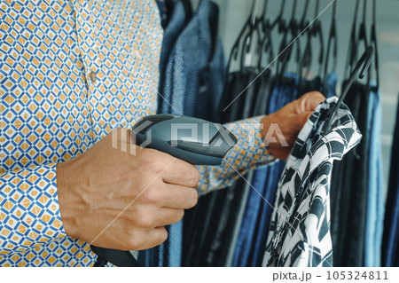 shop assistant uses a barcode scanner in a clothes shop using 105324811