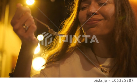A beautiful woman enjoys her dessert in cafe in the evening 105325287