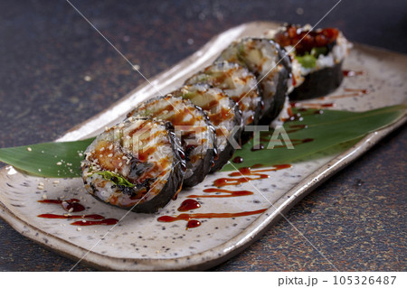 Sushi, delicious Japanese cuisine. Rolls of delicious sushi on a plate Sushi, delicious Japanese cuisine. Rolls of delicious sushi on a plate 105326487
