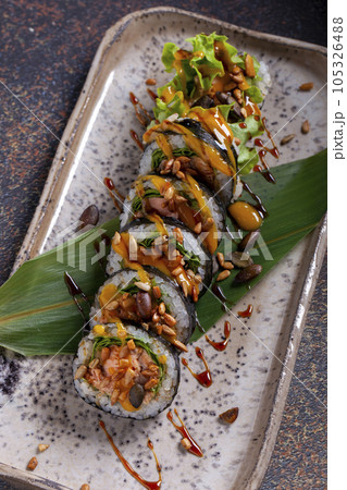 Sushi, delicious Japanese cuisine. Rolls of delicious sushi on a plate Sushi, delicious Japanese cuisine. Rolls of delicious sushi on a plate 105326488