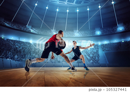 Motivated and competitive young men, basketball players in motion during match, game playing at 3D arena with flashlights 105327441