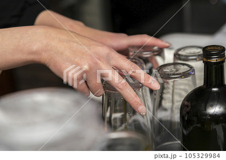スナックのカウンターでコップの整理をするママの手元 スナックのカウンターでコップの整理をするママの手元 105329984
