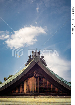 梅宮大社の夏、アオサギの飛ぶ夏空と拝殿の屋根 105330639