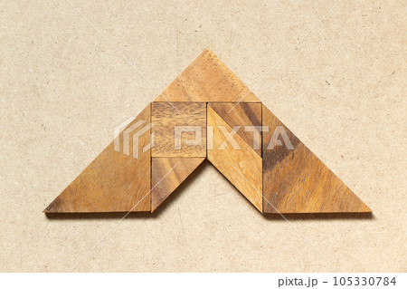 Wooden tangram in arrow shape on wood background Wooden tangram in arrow shape on wood background 105330784