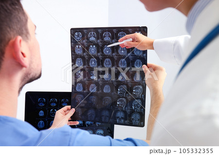 Doctors look at MRI images of a human head 105332355