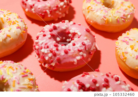 Glazed colored donuts on pink background, close up 105332460