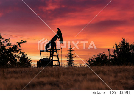 Pump jack silhouette on evening field 105333691