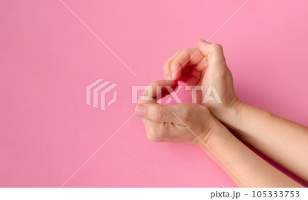 Women's hands in the shape of a heart on a pink background with space for text. High quality photo Women's hands in the shape of a heart on a pink background with space for text. High quality photo 105333753