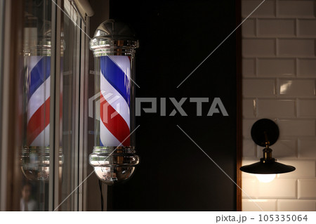 Barber shop vintage pole. copyspace Barbershop. Barber shop pole in red white and blue with lightbulb on top. 105335064