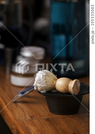 Set of shaving equipment and men's cosmetic products on wooden table, barbershop. shave concept with a straight razor, shaving brush and foam. beard care products for men on background. Set of shaving equipment and men's cosmetic products on wooden table, barbershop. shave concept with a straight razor, shaving brush and foam. beard care products for men on background. 105335083