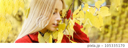 A young blonde woman walks around the autumn city in a red coat. The concept of urban style and lifestyle. Autumn portrait. A young blonde woman walks around the autumn city in a red coat. The concept of urban style and lifestyle. Autumn portrait. 105335170