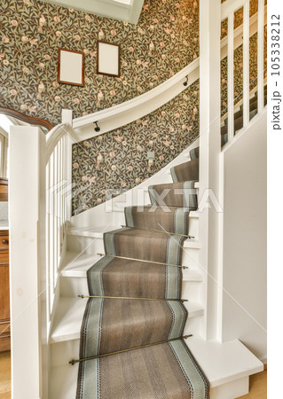 a stairway way with floral wallpaper on the walls and carpeted stairs leading up to an entryway area a stairway way with floral wallpaper on the walls and carpeted stairs leading up to an entryway area 105338212