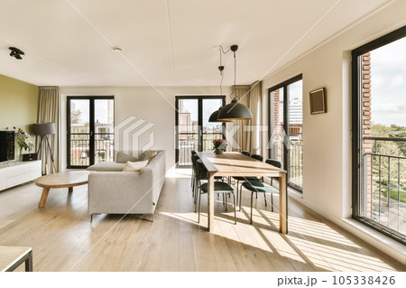 a living room with wood flooring and large windows looking out onto the cityscapearrons com a living room with wood flooring and large windows looking out onto the cityscapearrons com 105338426