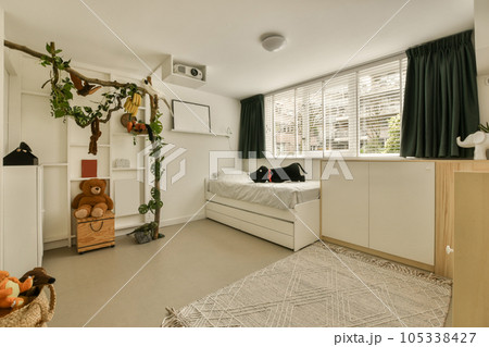 a bedroom with a bed and some plants in the window sid on the wall above the bed is a teddy bear 105338427