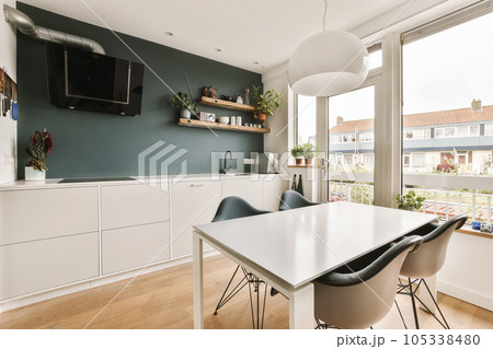 a dining room with a tv on the wall and some plants in pots sitting on top of the table 105338480