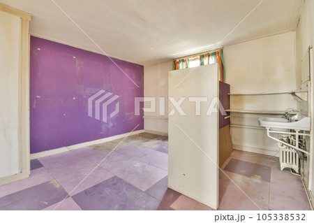 an empty room with purple paint on the walls and flooring area in front of the door to the bathroom an empty room with purple paint on the walls and flooring area in front of the door to the bathroom 105338532